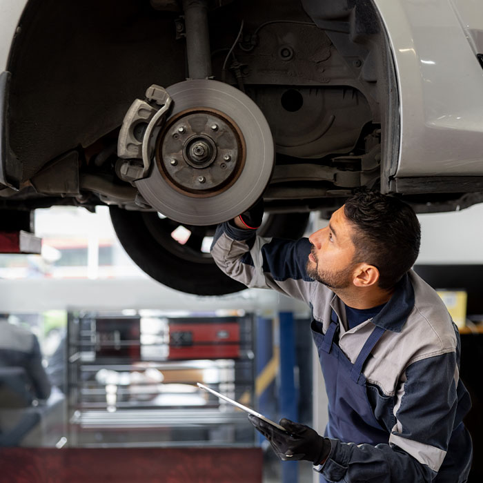 Mechanic aligning a car tire at an auto repair shop