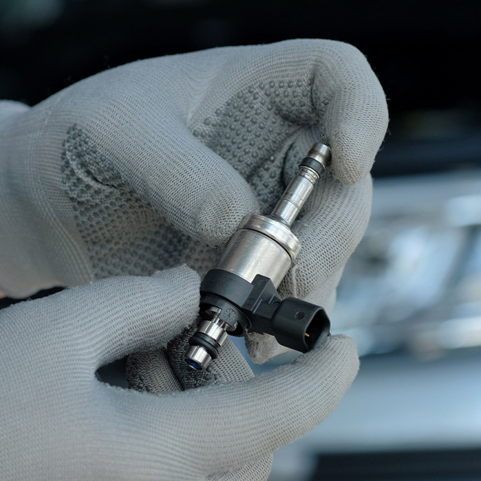 Mechanic holding a new fuel injector in his hands