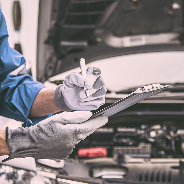 Mechanic checking inspection list after repairing car