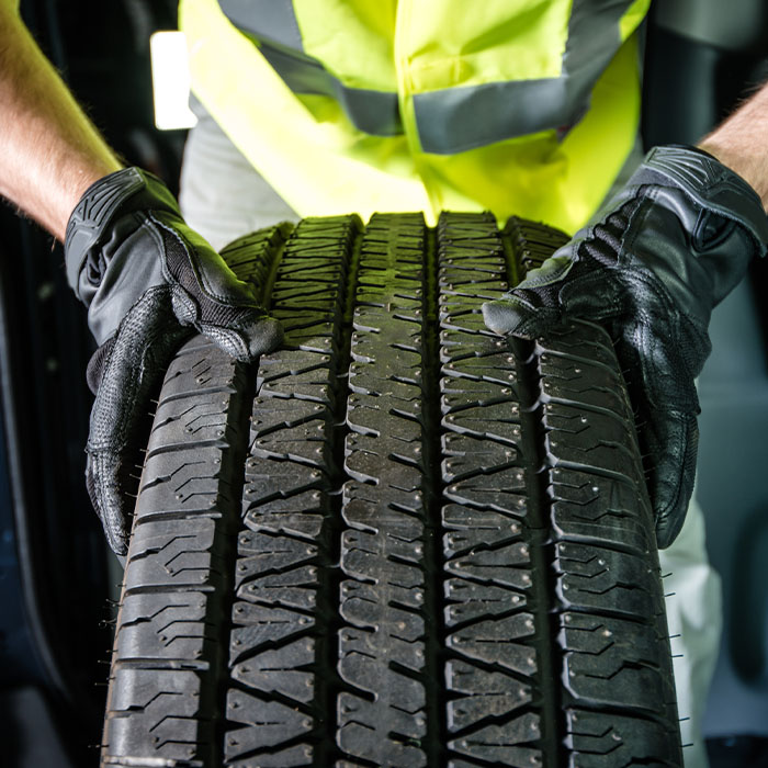 Man with brand new tire ready for installation