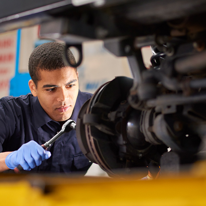 Mechanic is working on a car in a garage repair shop